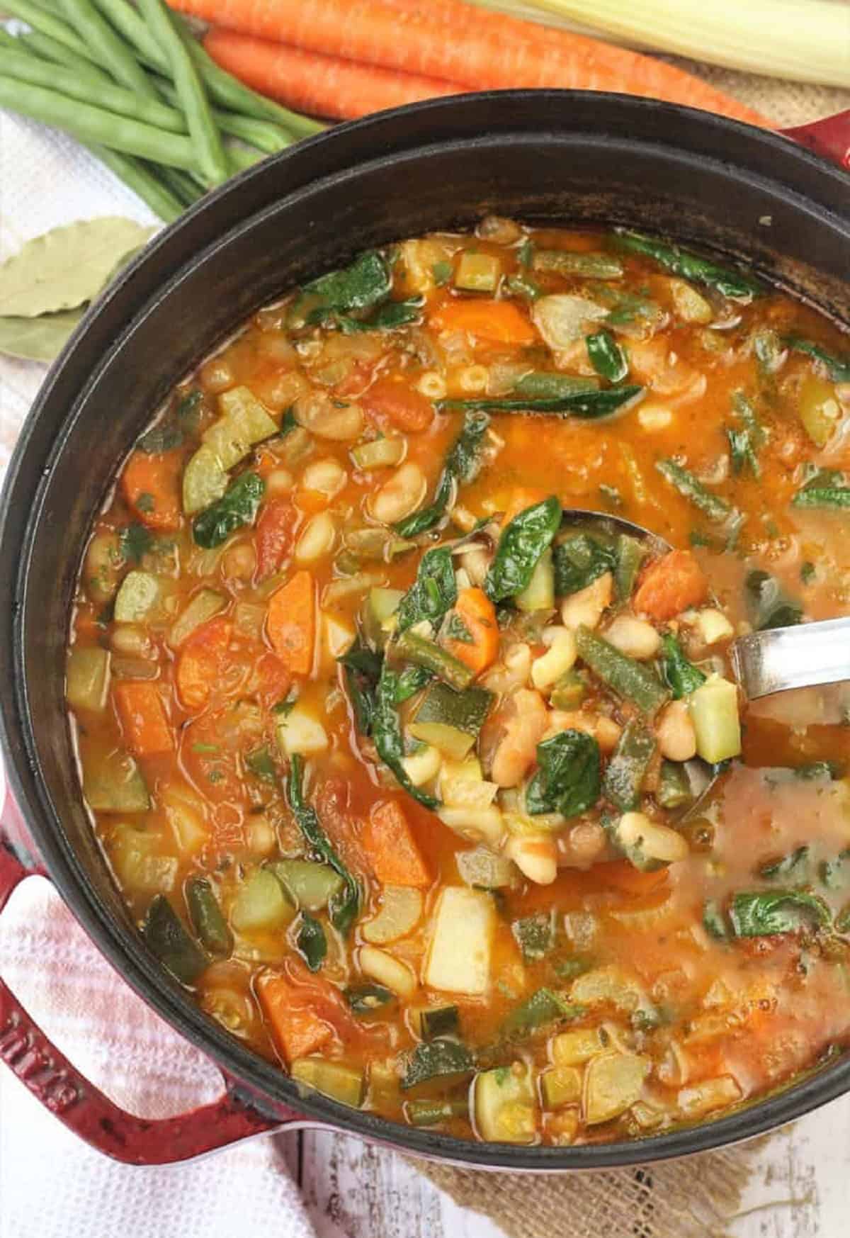 Italian vegetable and bean soup with pasta in sauce pan.