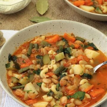 Bowl of Italian minestrone soup with spoon in it.