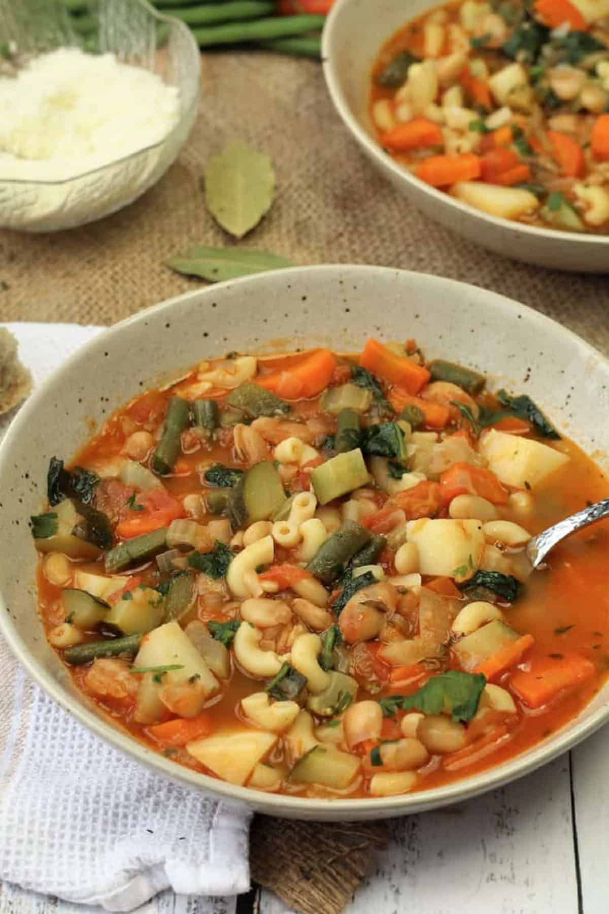 Bowl of Italian minestrone soup with spoon in it.