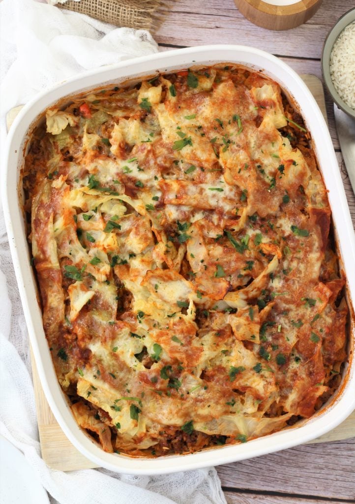 unstuffed cabbage roll casserole topped with mozzarella in white baking dish