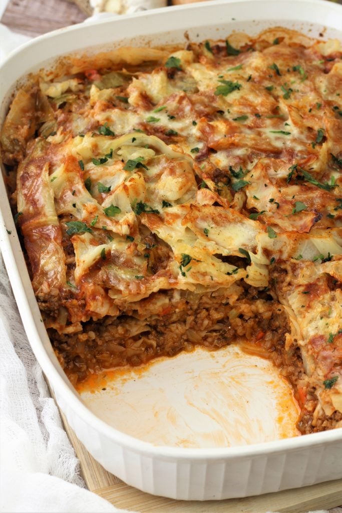 unstuffed cabbage roll casserole with piece cut out in white baking dish