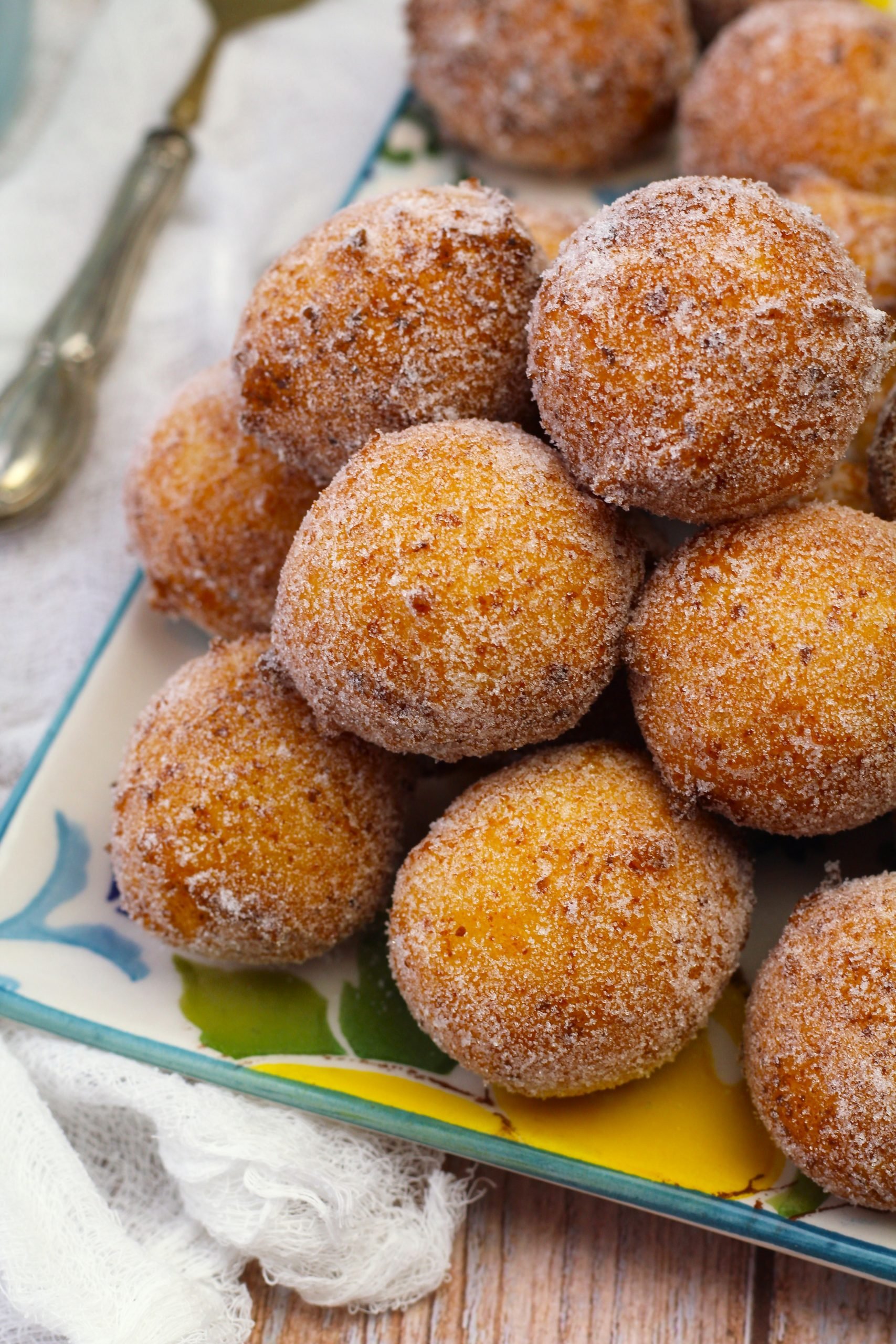 Pile of sugar coated ricotta doughnut holes on plate