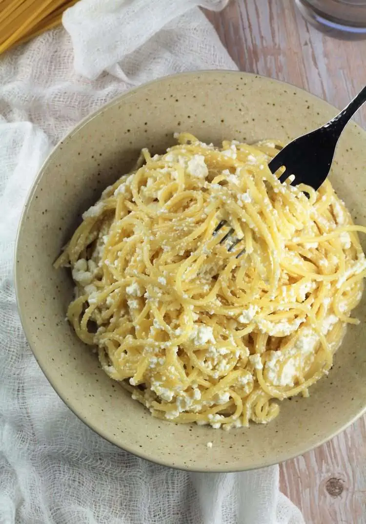 Overhead image of bowl of ricotta pasta with forkful twirled in it.