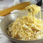 Forkful of spaghtetti with ricotta in bowl.
