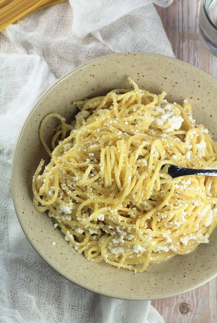 Bowl filled with creamy sauce pasta and fork twirled in it.