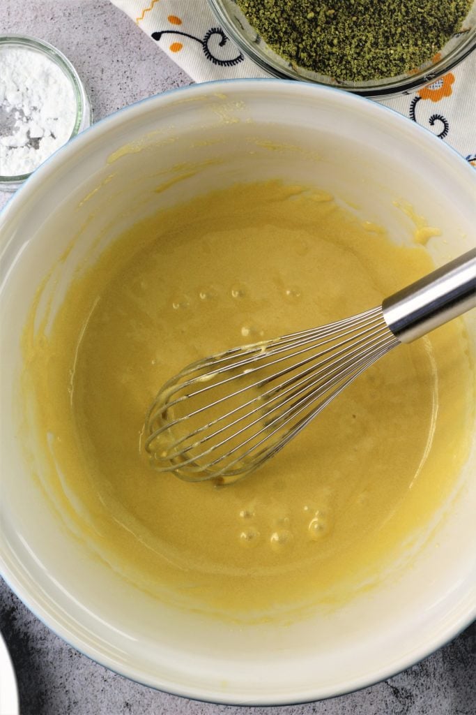 Whisked eggs and sugar in bowl with whisk.