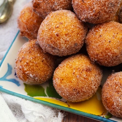 Pile of sugar coated doughnut holes with ricotta.