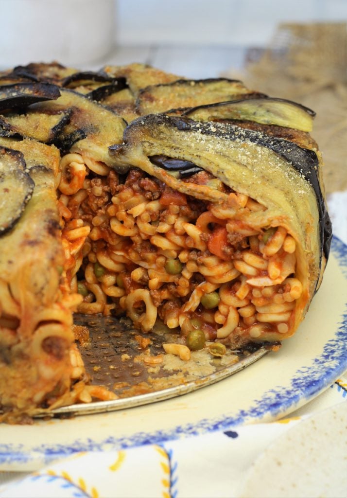 Baked anelletti in eggplant on plate.