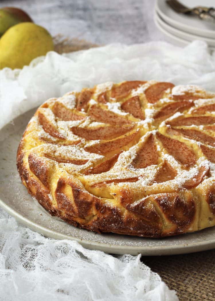 Pear topped ricotta cheesecake dusted with powdered sugar.