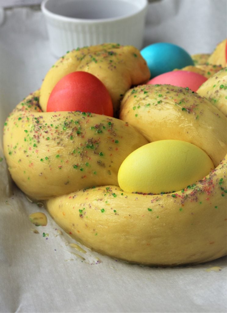 Braided brioche dough with colored eggs in it.