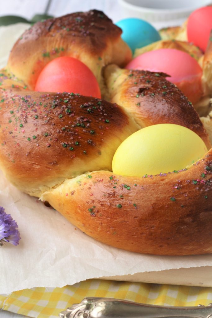 Braided Easter bread with colorful eggs and sprinkles.