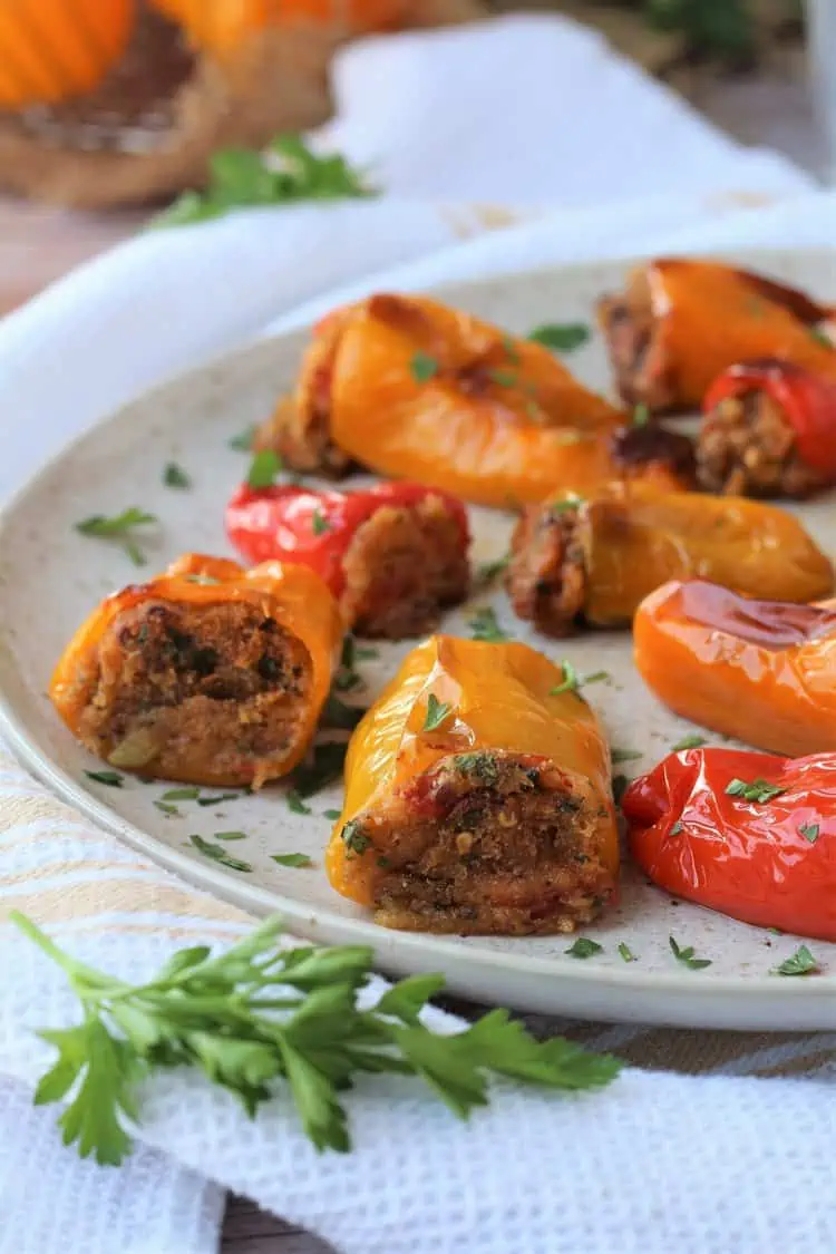 Mini sweet peppers with bread crumb filling on plate with parsley.