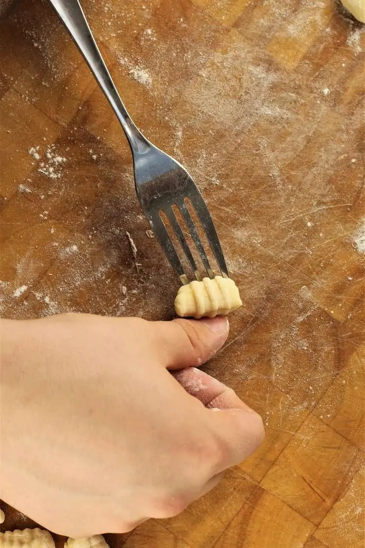 Rolling gnocchi with the tynes of a fork.