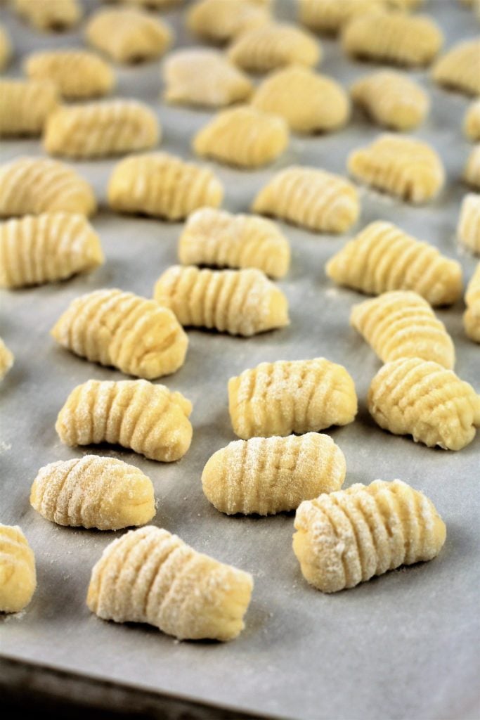 Ricotta gnocchi dumplings on baking sheet.