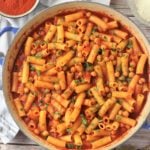 Pasta and chickpeas in tomato sauce in blue skillet.