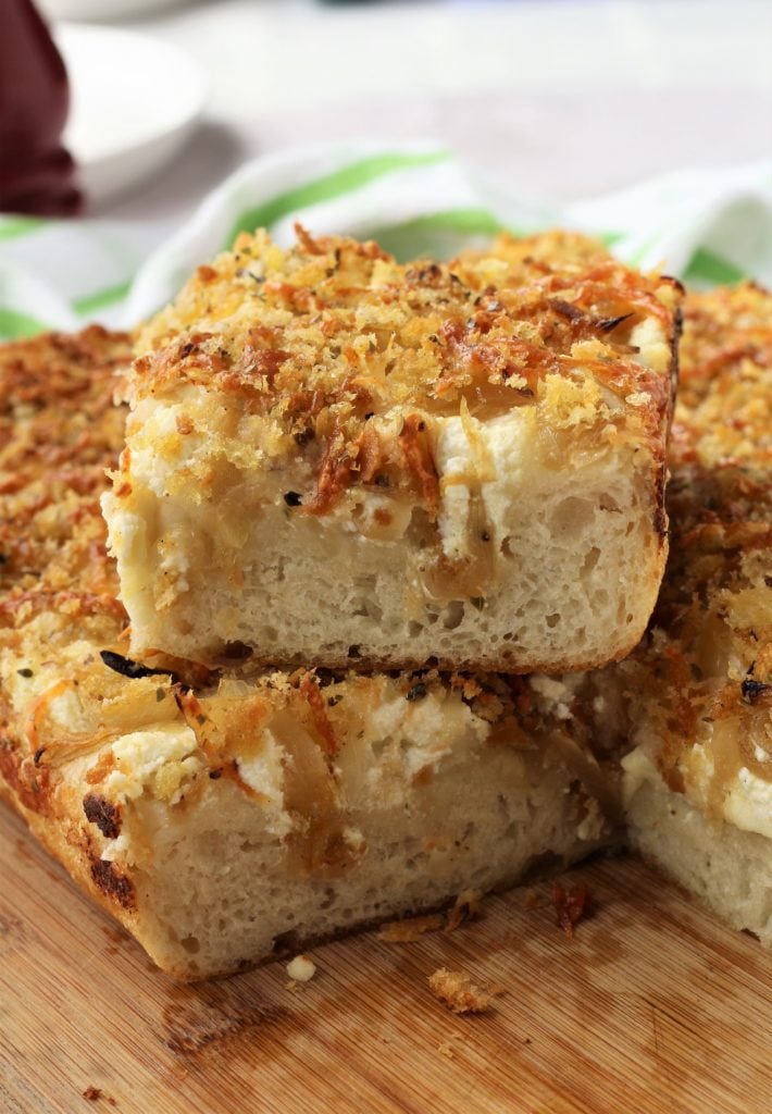 Slice of white sfincione toppped with breadcrumbs.