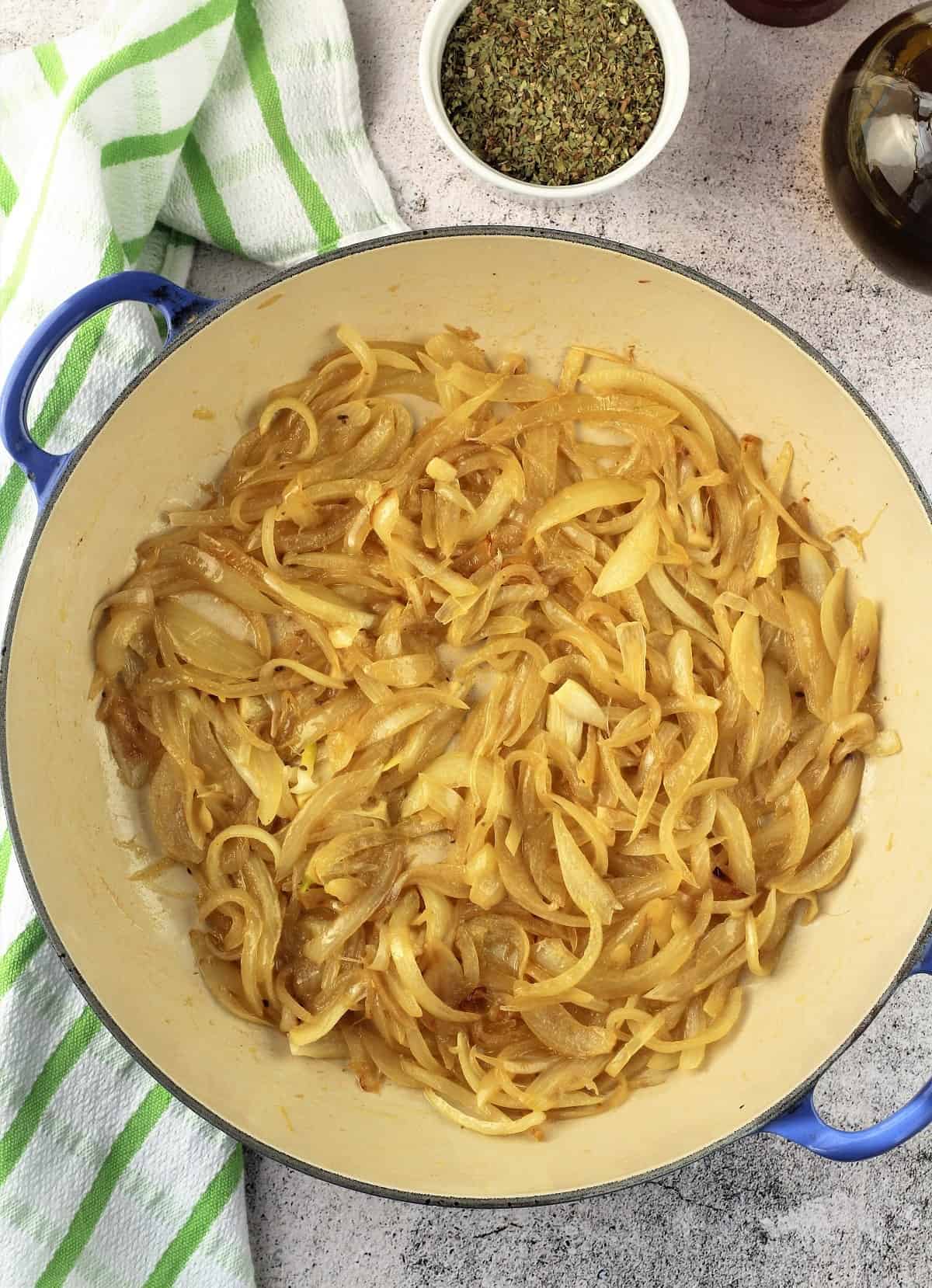Sliced onions sautéed in large skillet for sfincione recipe.