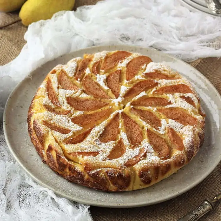 Pear topped ricotta cheesecake on plate.