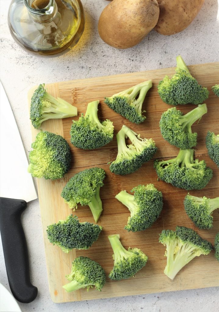 Broccoli florets cut on wood board.