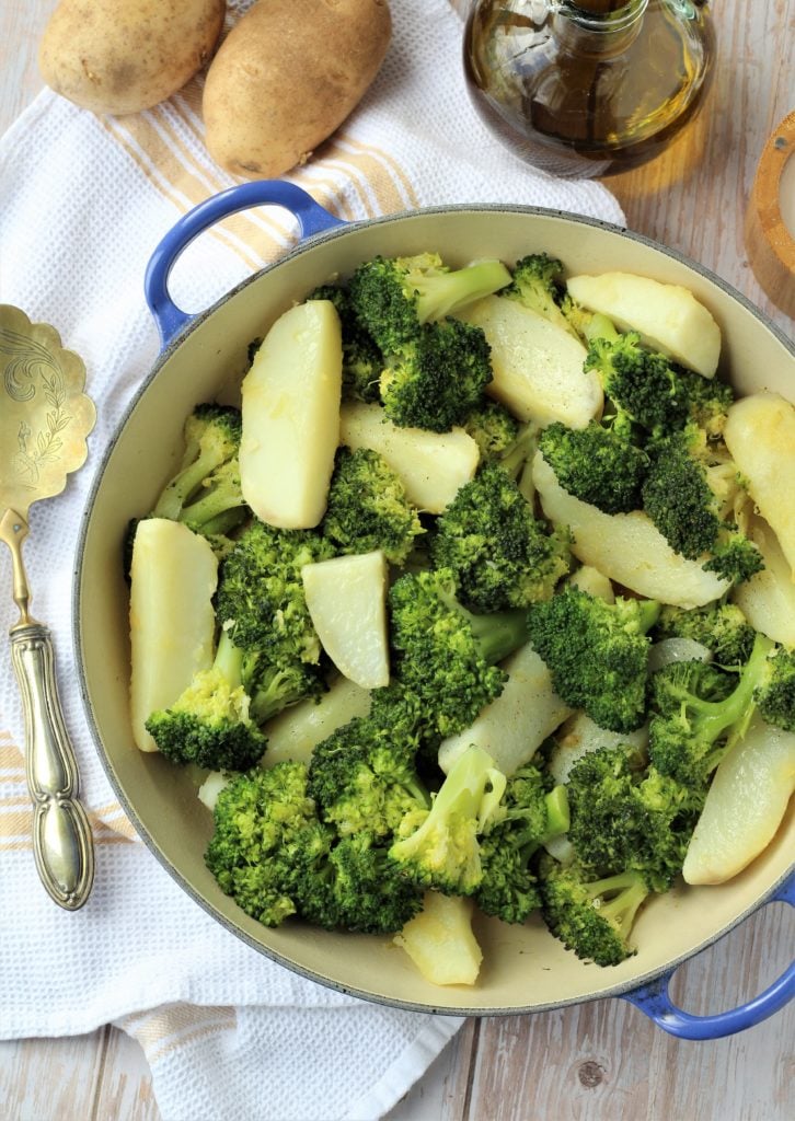 Blue skillet filled with broccoli and potatoes.