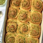 Baking pan with pistachio cream rolls on wire rack.