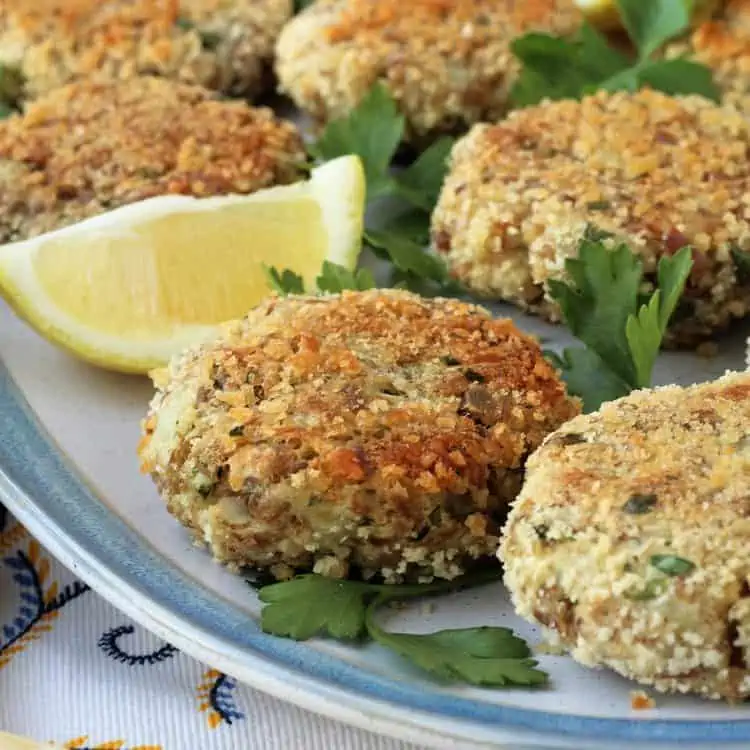 Tuna potato patties on plate with lemon wedge.