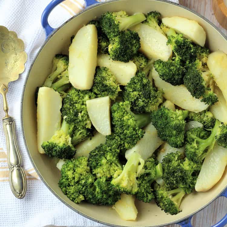 Broccoli and potatoes in blue skillet.
