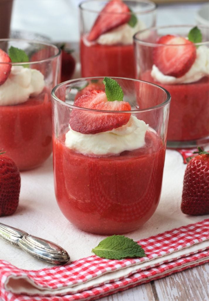 Glass filled with gelo di fragole topped with whipped cream and mint.