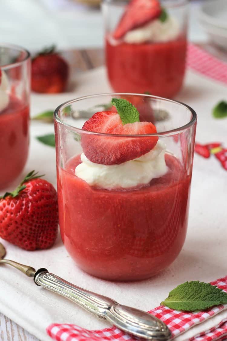 Glass of Sicilian strawberry pudding topped with whipped cream and mint.