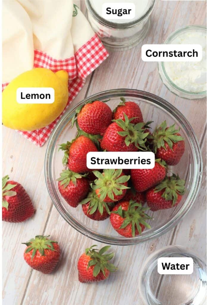 Bowl of strawberries, sugar, cornstarch, water, and lemon.