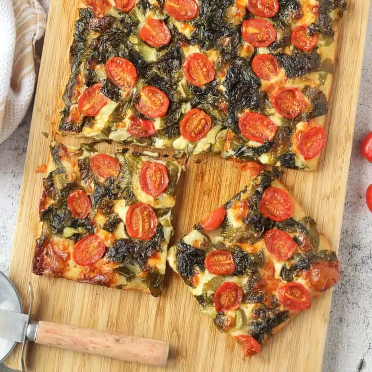 Sliced focaccia messinese on wood board.