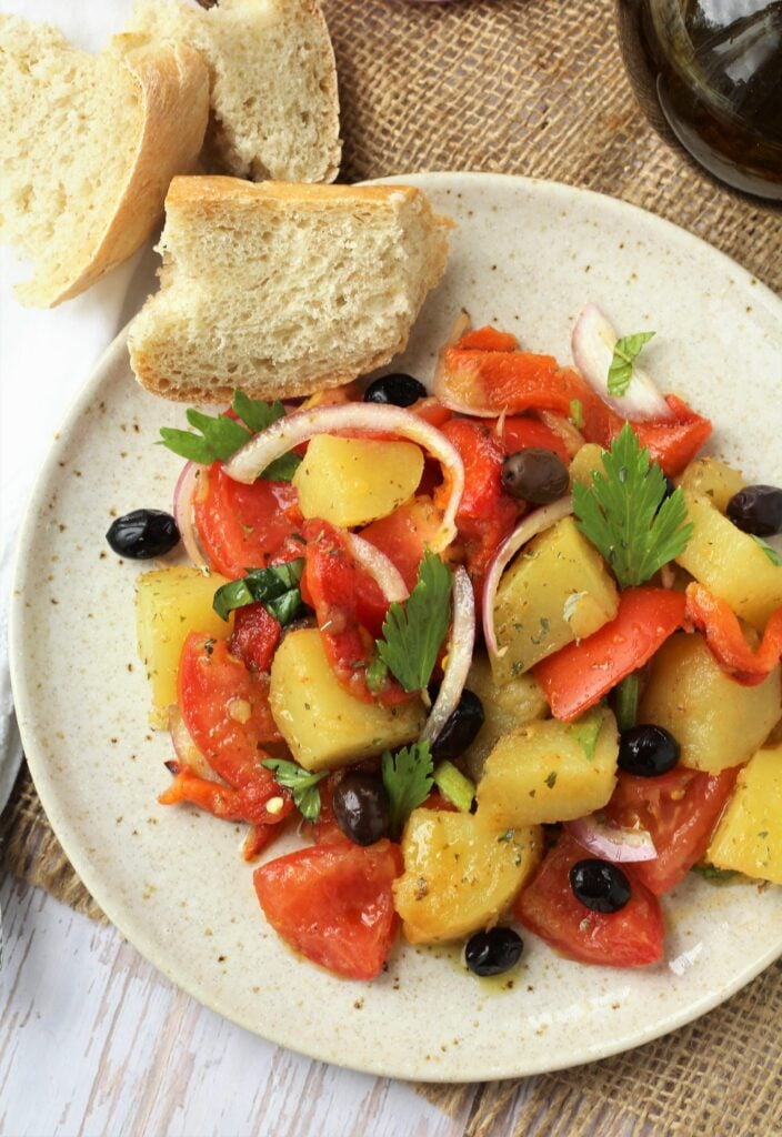 Plated Italian potato salad with red peppers and tomatoes.