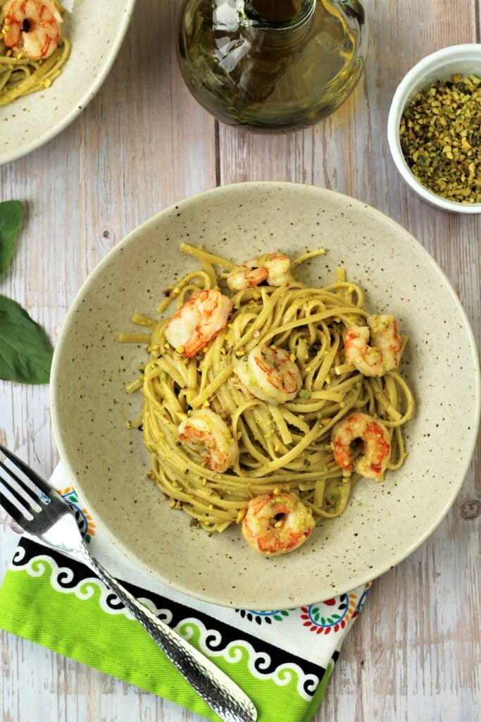 Plated pasta with prawns and pistachio pesto.