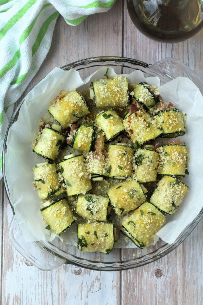 Round baking dish filled with zucchini roll ups.