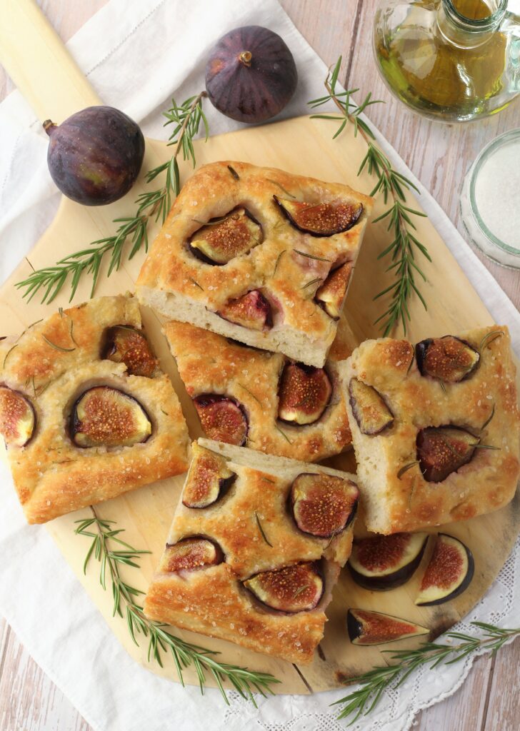 Wedges of fig rosemary focaccia on serving board.