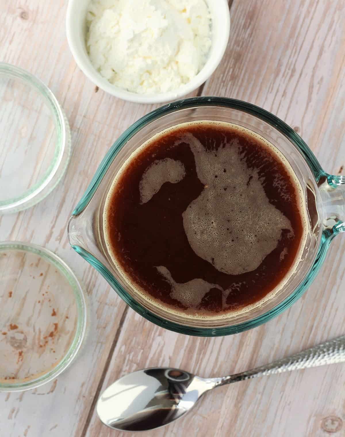 Brewed espresso coffee in glass cup next to bowl with sugar for gelo di caffè.