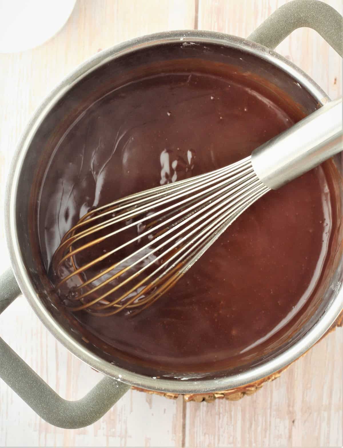 Thickened Sicilian coffee pudding in sauce pan with whisk.
