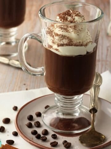 Sicilian coffee pudding (gelo di caffè) served in glasses topped with whipped cream.