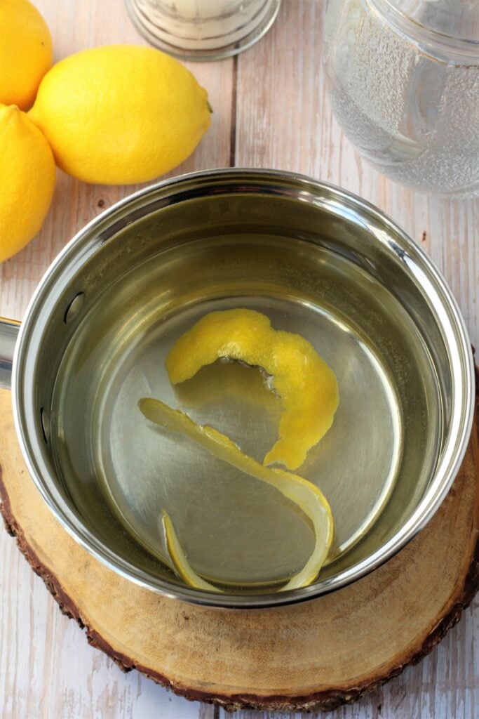 Sauce pan with water and lemon peel strips.