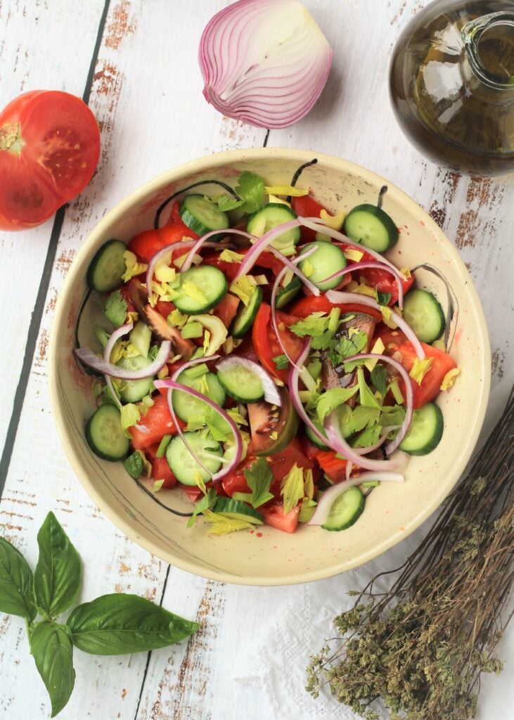 Sliced tomatoes, cucumber and onions for salad in bowl.