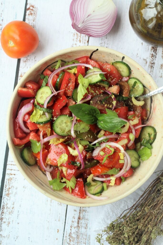 Tossed tomato cucumber salad in bowl.