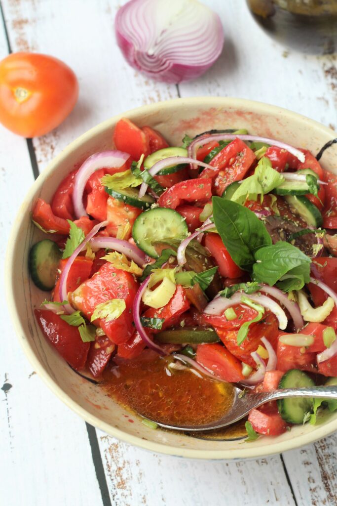 Tomato onion salad with spoonful of tomato juices.