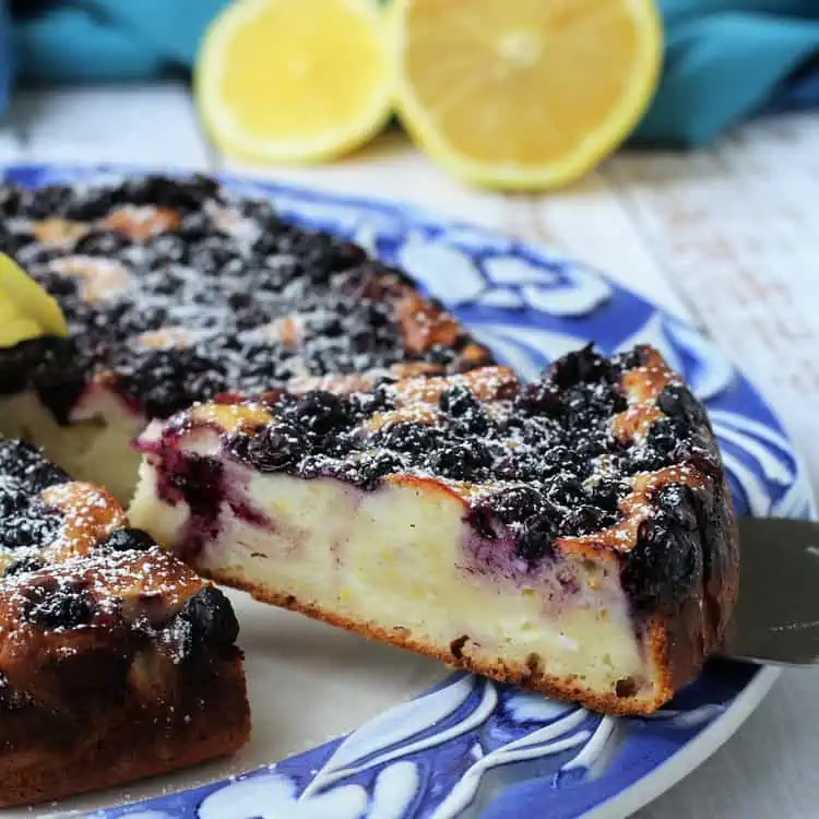 Wedge of ricotta berry cake served on spatula.