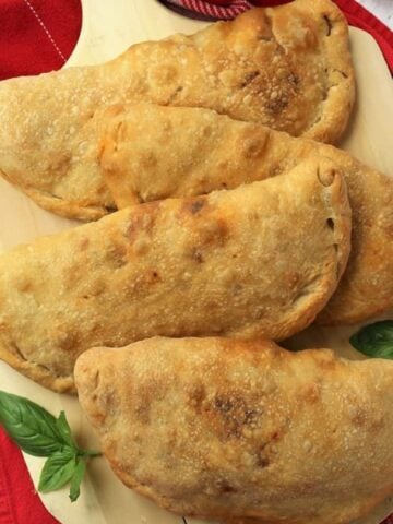 Eggplant calzone alla Norma on wood board.