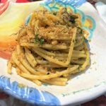 Plate with pasta with sardines topped with breadcrumbs.