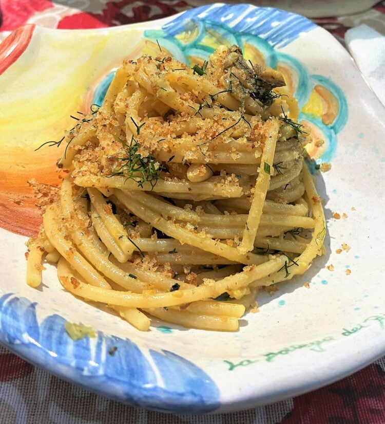 Plate with pasta with sardines topped with breadcrumbs.