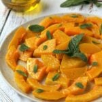 Sweet and sour squash topped with mint on plate.