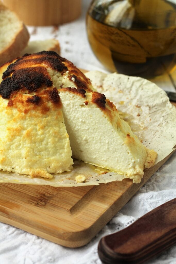 Baked ricotta wedge on cutting board.