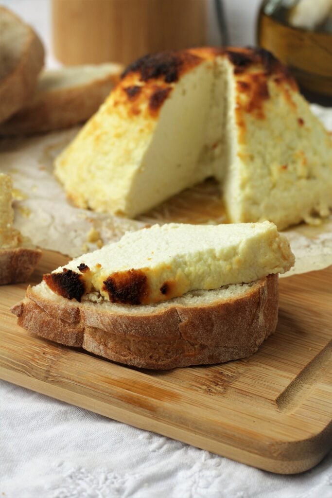 Slice of baked ricotta on bread slice.