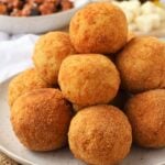 PIled arancini balls on plate.